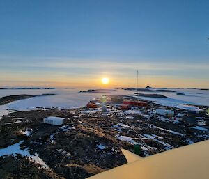 View of an Antarctic station with the sun setting in the background