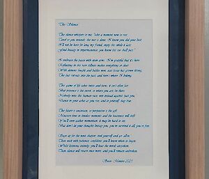 Picture of the poem printed in blue cursive font, in a wooden frame.