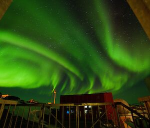 A large green aurora soars over the buildings of the station