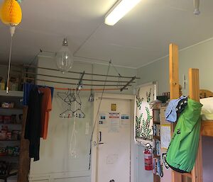 The inside of an old hut with bunks and a drying rack