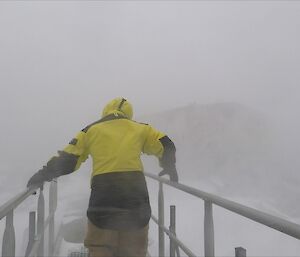 A person crosses a walkway with heavy wind blown snow