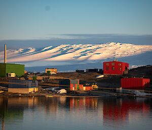 A colourful Antarctic station with an ice plateau in the distance