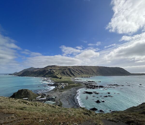 A view of an island's isthmus surrounded by blue skies and water