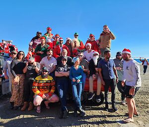 People gather with Santa Claus outside in the sun