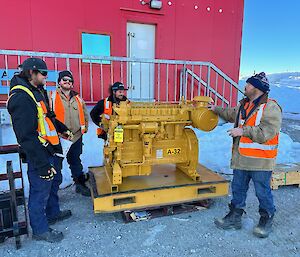 Four men in work gear pose next to a 250kVa generator outside