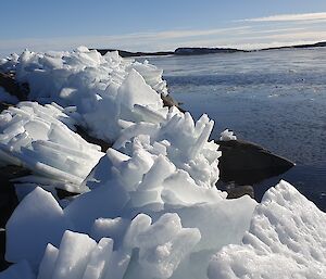 Chunks of white sea-ice have mounded up on the rocks that surround the shores of Davis - they look like icy prisms.