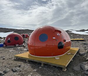 A shiny, new-looking red domed field hut