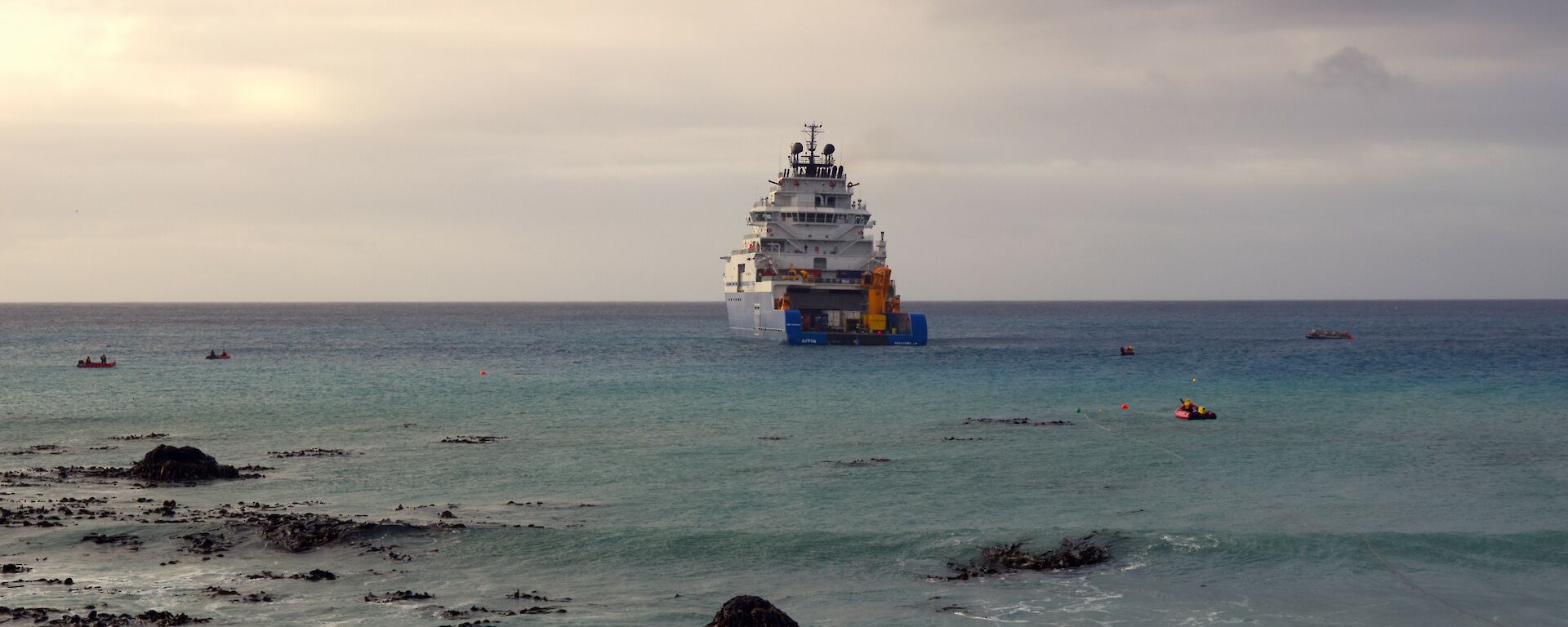 A blue and white ship undertaking refuelling operations in Buckles Bay at Macquarie Island