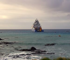 A blue and white ship undertaking refuelling operations in Buckles Bay at Macquarie Island