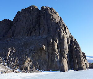 A rocky peak rises above snow and ice