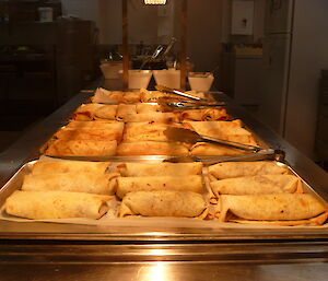 Trays of burritos at a servery