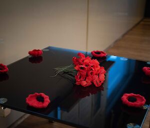 Red poppies on a table for Anzac Day