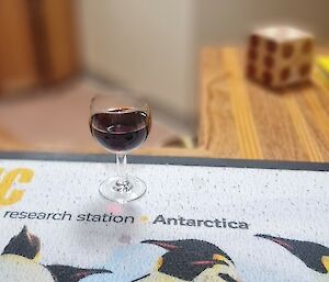 A glass of port sits on the bar