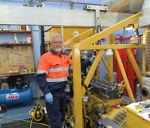 A man in hi vis works on a large yellow machine