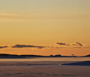 Icebergs appear to float above the horizon beyond islands in the distance