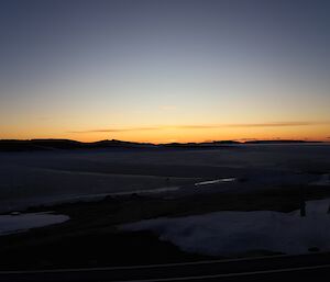 An orange glow from the horizon marks sunset