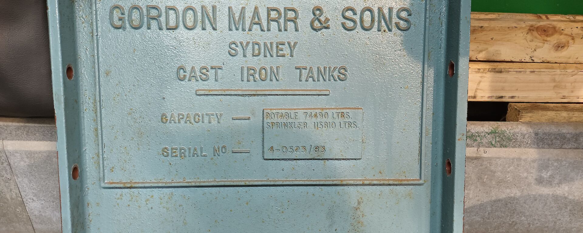 This photo is a close up of one of the original light blue metal plates of the water tank and is approximately 45cm square. It bears the words "GORDON MARR & SONS, SYDNEY, CAST IRON TANKS".