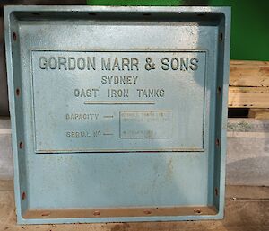 This photo is a close up of one of the original light blue metal plates of the water tank and is approximately 45cm square. It bears the words "GORDON MARR & SONS, SYDNEY, CAST IRON TANKS".