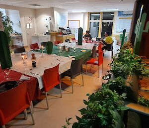 A large table is set with Mexican decorations and red, white, and green tablecloths