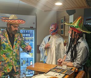 Three men in costume are at a bar