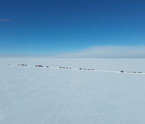 Aerial view of five tractors pulling a series of sleds