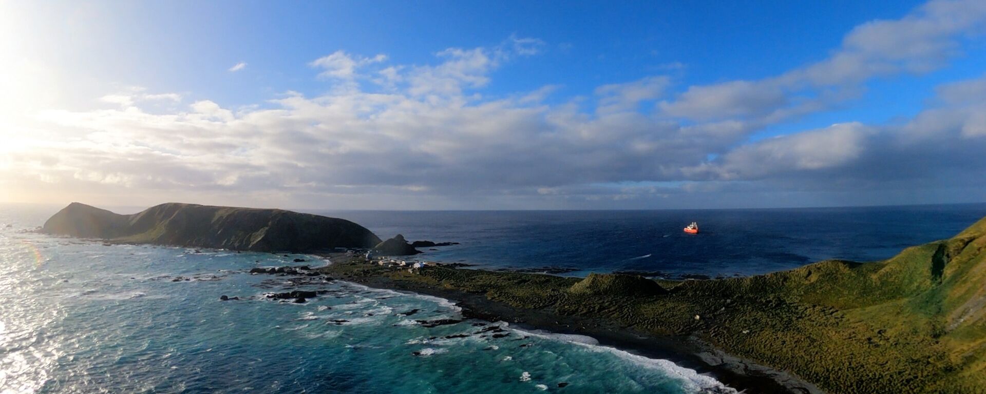 Aerial view of Macquarie Island and a red and white ship.