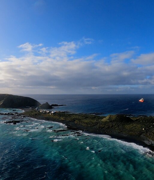 Aerial view of Macquarie Island and a red and white ship.