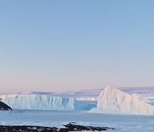 Two icebergs are locked in place by sea-ice