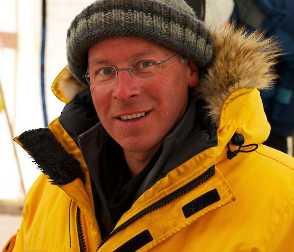 A man in a yellow jacket and beanie