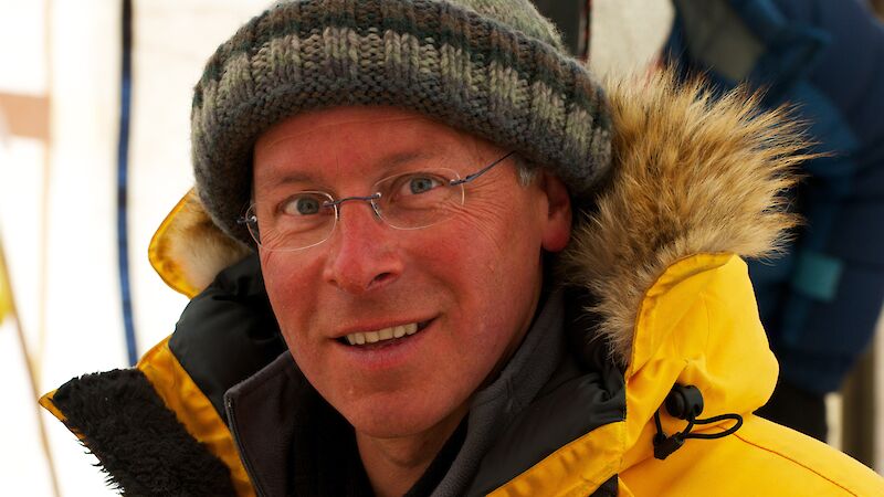 A man in a yellow jacket and beanie