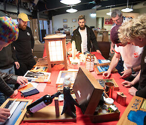 A group of people stand around a table admiring Midwinter's gifts