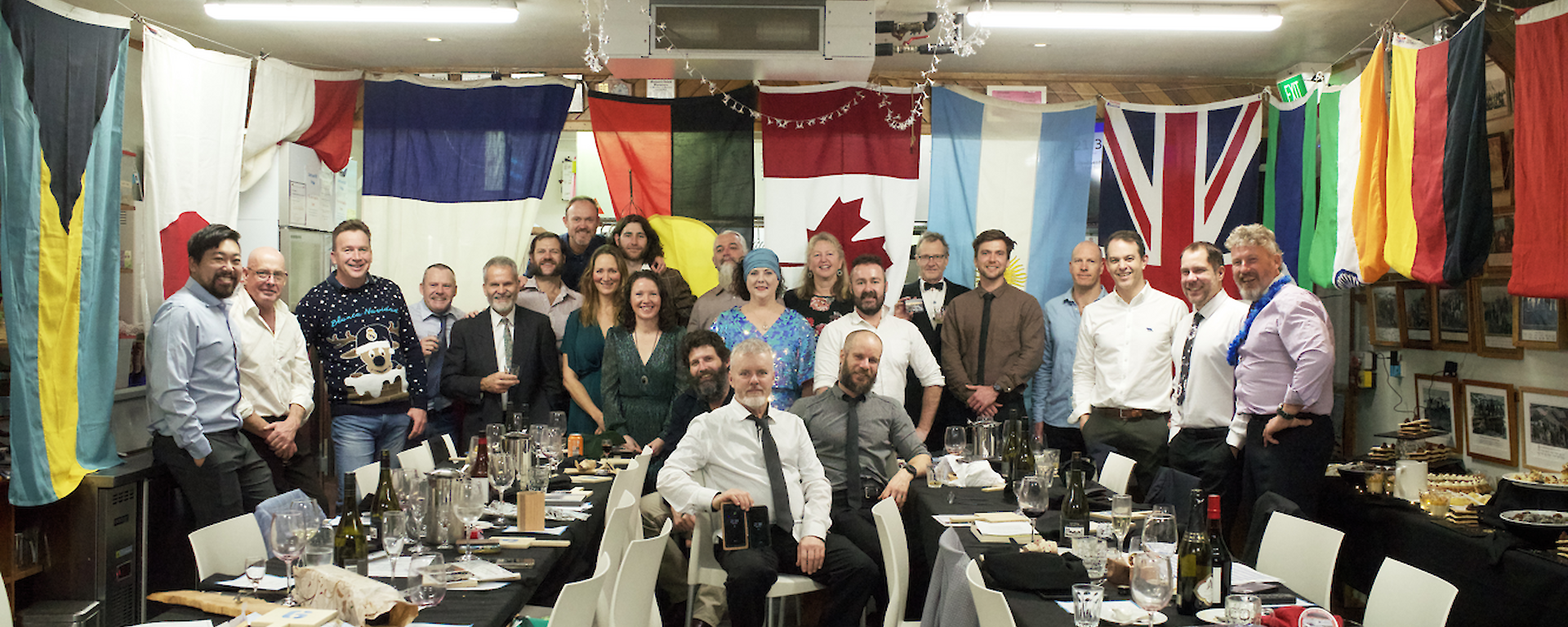A group of people in front of a row of flags for a formal dinner