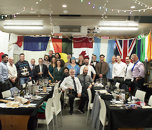 A group of people in front of a row of flags for a formal dinner