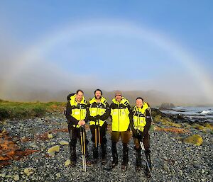 Macca expeditioners silhouetted by a rainbow