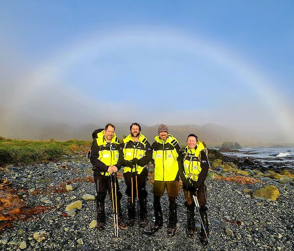 Macca expeditioners silhouetted by a rainbow