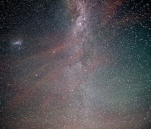 A picture of the night sky with red, orange, green and blue colours being formed by the Milky Way galaxy and the aurora australis.