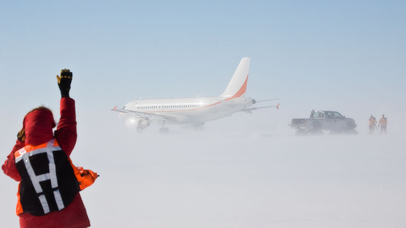 Expeditioner waving at aircraft taking off