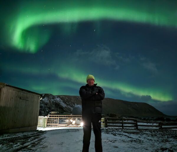 2023 winter plumber Wayne Phillips standing underneath an aurora - Macquarie Island.