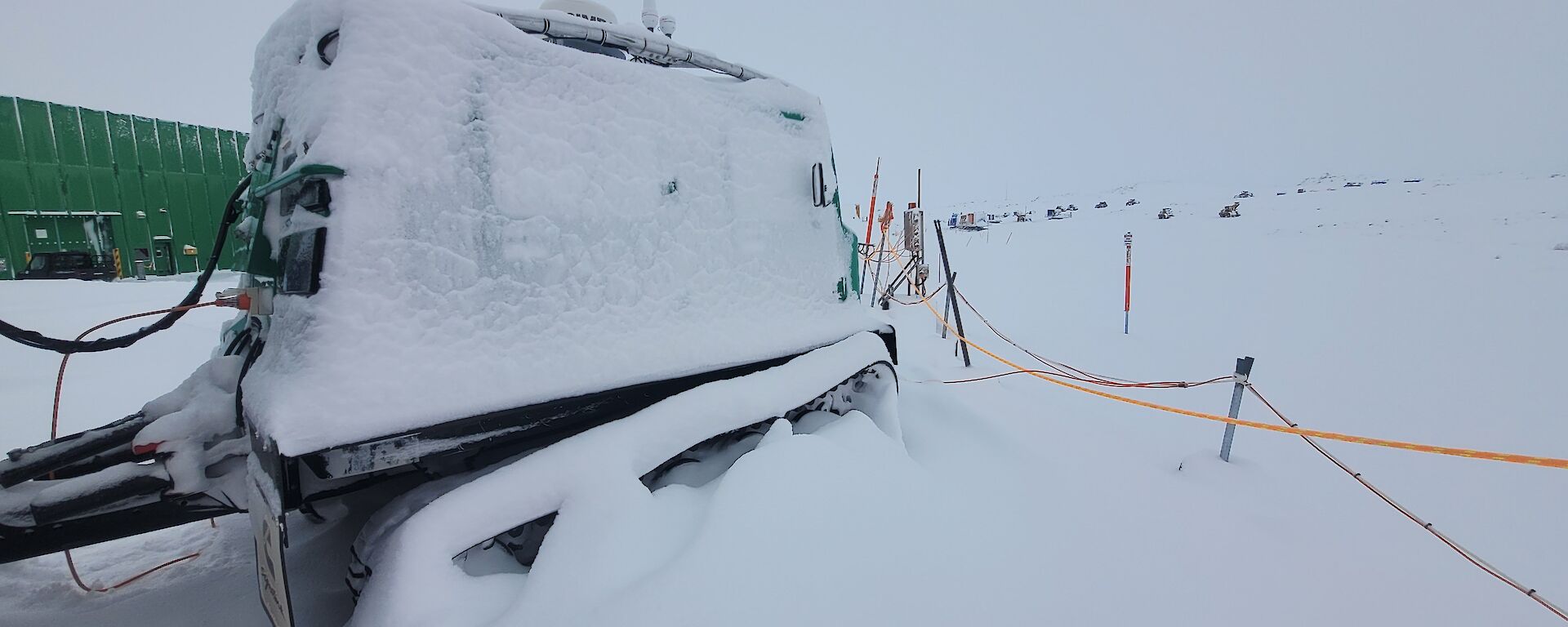 A snow encased green Hagglunds vehicle