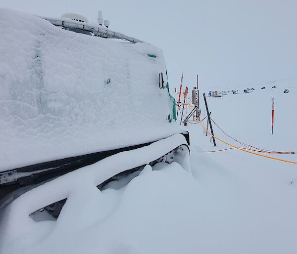 A snow encased green Hagglunds vehicle