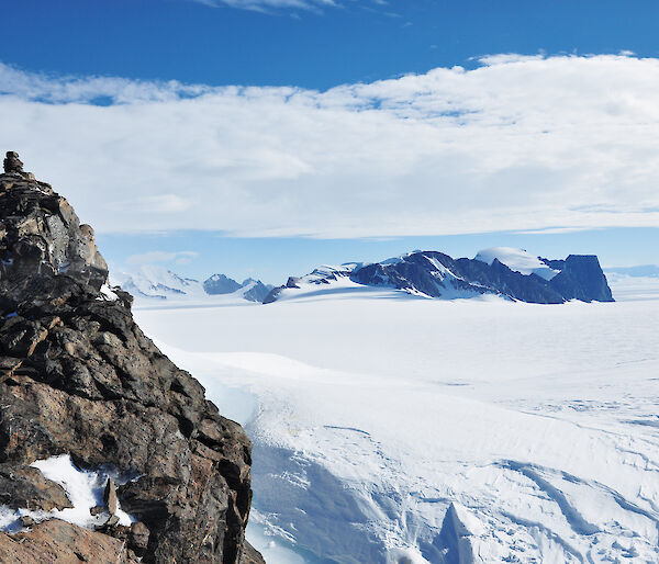 A rocky outcrop and distant snow-covered mountain range