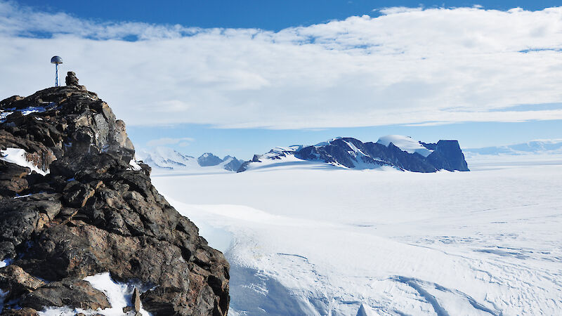 A rocky outcrop and distant snow-covered mountain range