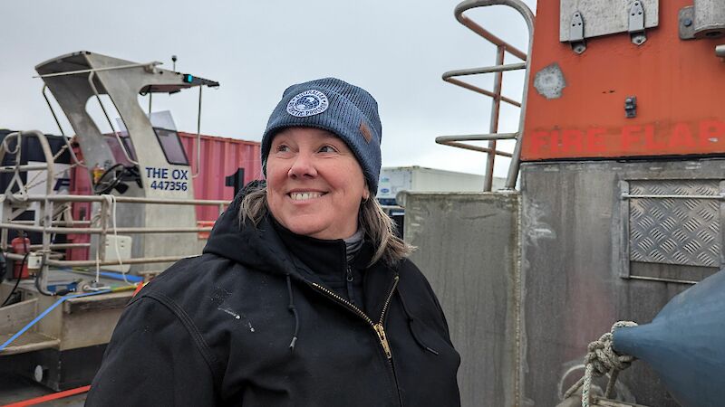 A woman in a beanie standing in a barge.