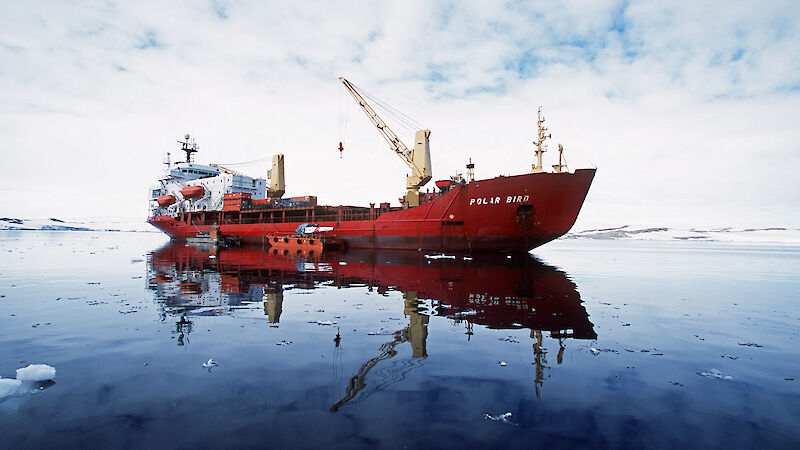 A red ice breaking ship surrounded by ocean and ice