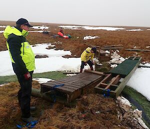 Two expeditioners either side of a wooden bridge