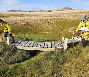 Expeditioners measuring a wooden bridge