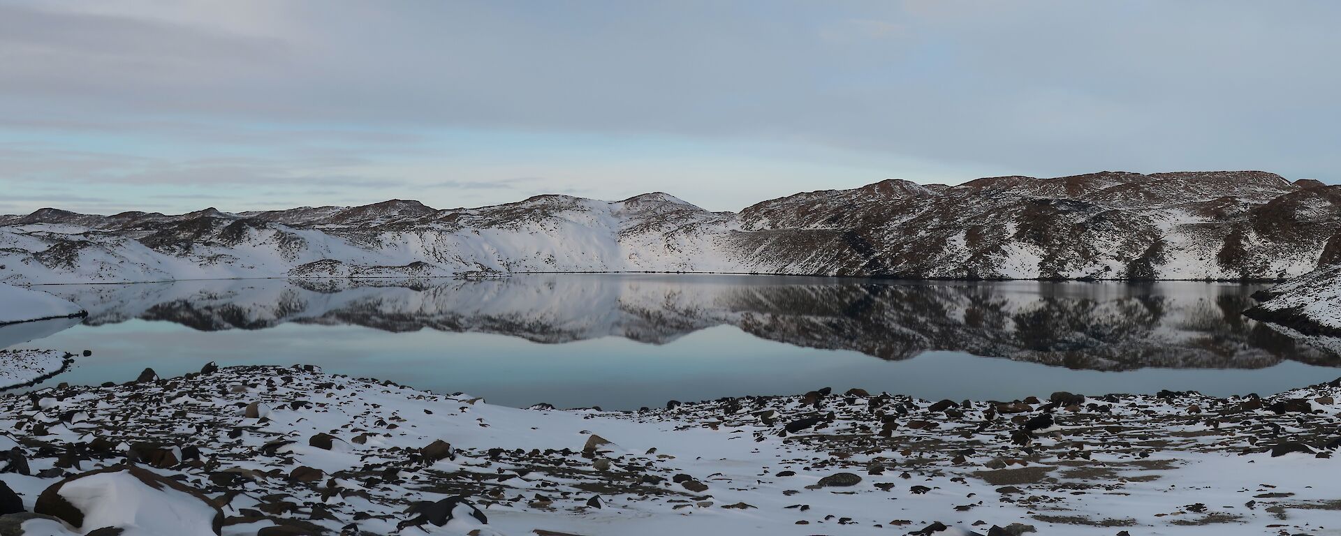 Panoramic image of the Deep Lake embedded in snowy rock
