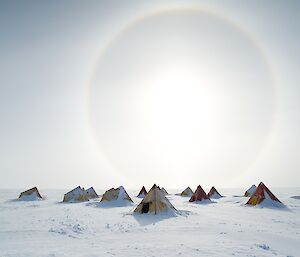 A group of polar pyramid tents on snow.