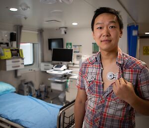 A man showing off a small medical device attached to his chest, under his shirt.