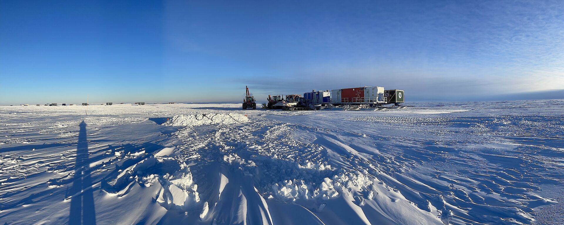 The traverse cargo laydown area (Goat yard) with the camp in the foreground. Snow groomers are used to level the area and remove the excess snow that had built up.